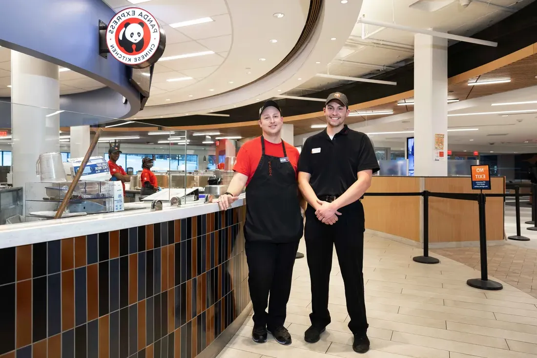 Food service staff standing and smiling.